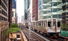The Train Moving On The Tracks Wall Mural features a silver elevated “Kimball” train gliding through downtown Chicago’s glass and steel skyline, with vibrant city details and greenery—ideal for adding urban flair to your space.