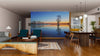 Modern living and dining area with wood floors, teal chairs, Tree Silhouette Wall Mural (peel and stick), unique wood coffee table, pendant lights, dining table, and open kitchen in the background.