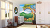 A bright nursery features the Tropical Animal Fun Wall Mural, showing a giraffe, lion, and parrots under a rainbow with green mountains. A white crib, rainbow stacking rings, wooden horse, and woven basket complete the cozy space.