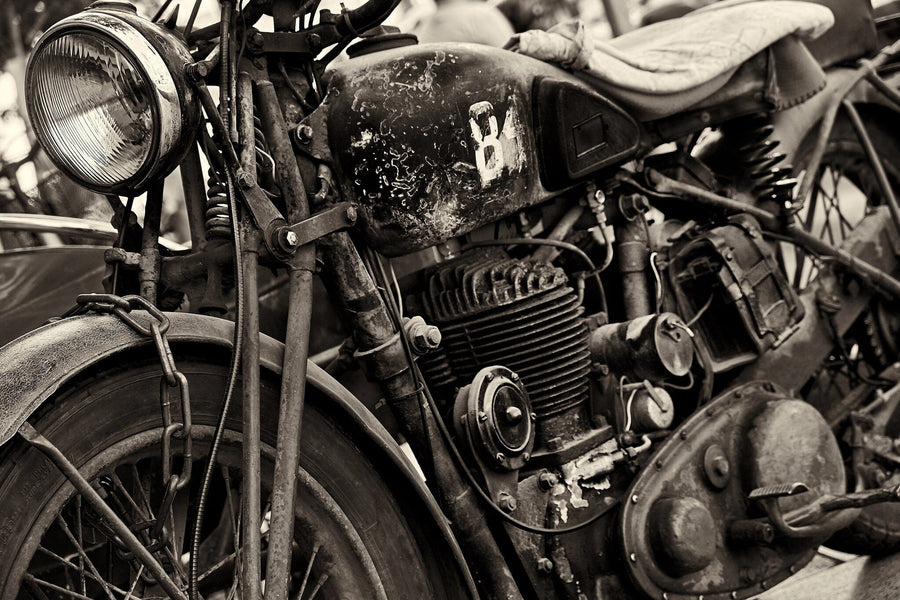 A clean garage with cabinets, organized tools, and a vintage motorcycle. Sunlight streams in as the back wall features the Vintage Ride Wall Mural—a peel and stick close-up black-and-white classic motorcycle engine design.