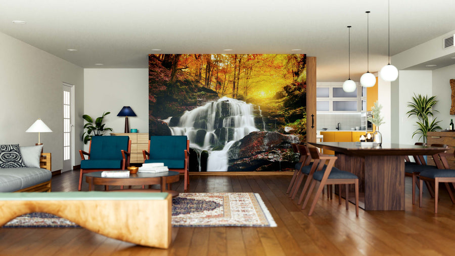 A modern open-plan living and dining area features wood floors, teal and wooden furniture, pendant lights over the dining table, and a large removable Waterfall Cascade Wall Mural depicting a forest waterfall with autumn foliage.