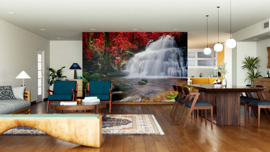 A modern open living-dining space with wooden floors, chic blue and green furniture, plants, and contemporary lighting. The centerpiece is the "Waterfall in Rainforest Wall Mural," creating a stunning natural focal point.