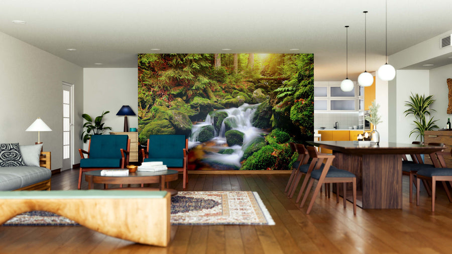 A modern open living-dining area features wooden floors, mid-century furniture, and a large Waterfall on Mountain Stream Wall Mural that brings nature indoors. Pendant lights hang above the table; the kitchen is visible in the background.