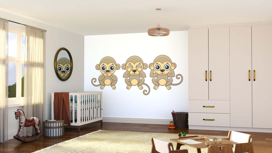 A nursery room features a crib, plush rug, toys, and a wardrobe. The Wise Monkeys Wall Mural shows “see no evil, hear no evil, speak no evil.” A round monkey-face mirror hangs nearby while light streams through sheer curtains.