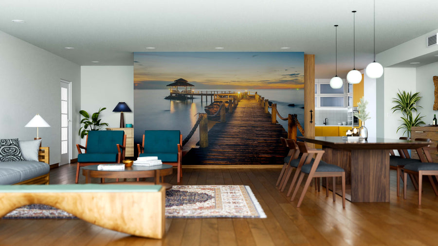 A modern living-dining room features wooden floors, blue armchairs, a wooden table with chairs, pendant lights, and a Wooden Bridge Landscape Wall Mural that adds depth and tranquility to the bright, open space.