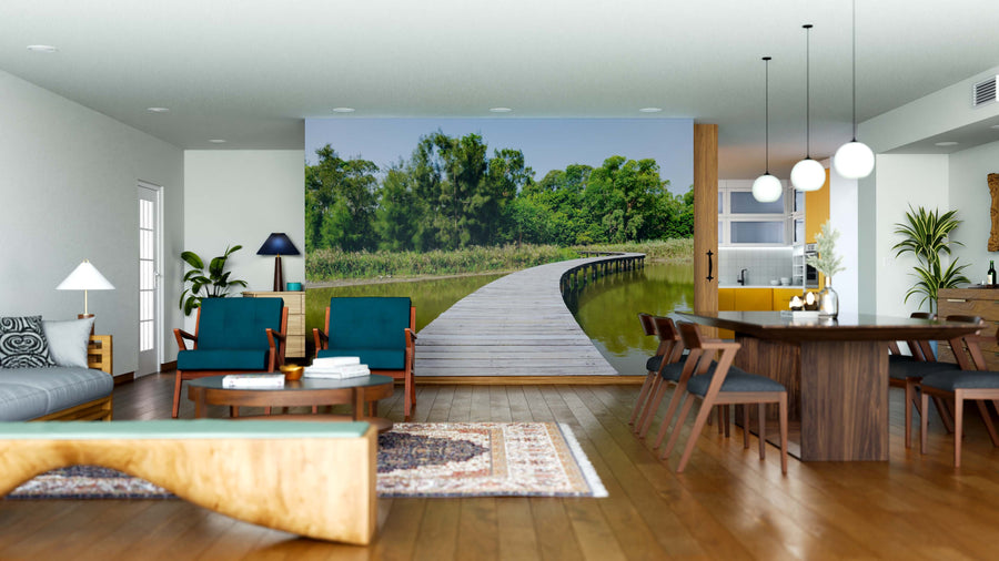 A modern living-dining room with wood floors, teal chairs, and a gray sofa centers around a dining table. The back wall features the Wooden Walkway Wall Mural, seamlessly blending indoor comfort with outdoor beauty.