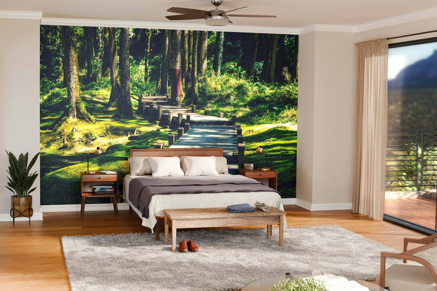 A modern living-dining area features wooden floors, teal armchairs, a long dining table, pendant lights, and the Wooden Walkway in the Forest Wall Mural for a serene, natural accent to the contemporary décor.