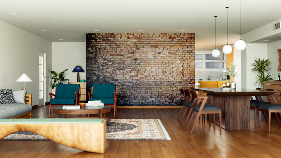 A modern living and dining area features the Worn Old Brick Wall Wall Mural as a central accent, with wooden floors, green armchairs, a light gray sofa, a patterned rug, and pendant lights illuminating the dining table.