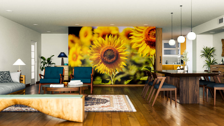 Open-plan living and dining area featuring wood floors, modern furniture, and pendant lights. The Yellow and Orange Sunflowers Wall Mural adds a bold, vibrant focal point, paired with blue, green, wood tones, and lively plants for fresh decor.