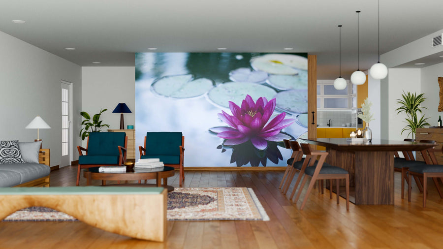 A modern living-dining space with wood floors, teal chairs, and a dark wood table is centered around the Floating Water Lily Wall Mural—a striking custom design of a pink lotus and lily pads that elevates this open, stylish room.