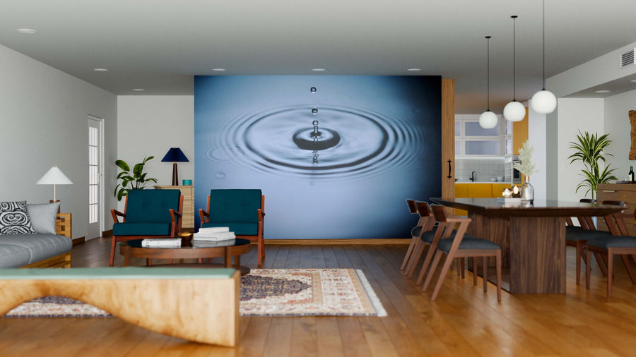 A modern open living-dining area features wood floors, dark teal chairs, a wooden dining table, and the Splash on Water Wall Mural. Pendant lights, contemporary décor, and rugs add warmth and complete the inviting space.