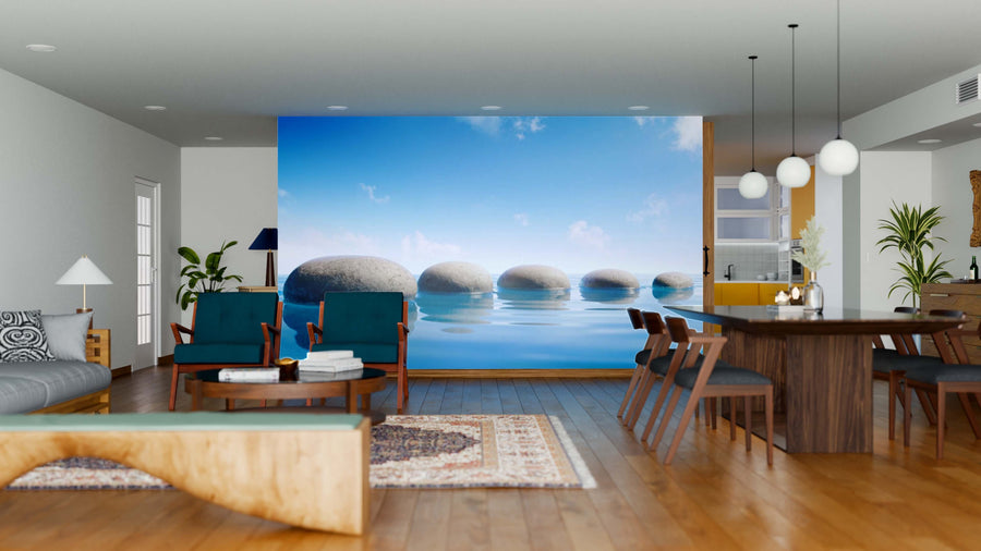Modern open living and dining area with wood floors, stylish furniture, pendant lights, and the Step Stones In Blue Water Wall Mural as a serene, nature-inspired focal point featuring smooth stone balls in calm water against a bright blue sky.